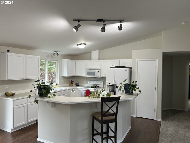 kitchen with vaulted ceiling, a breakfast bar, white cabinets, and white appliances