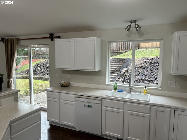 kitchen with dark hardwood / wood-style flooring, dishwasher, white cabinets, and sink