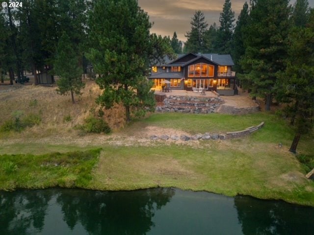 exterior space with a water view, a lawn, and a patio area