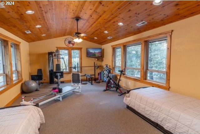 carpeted bedroom featuring ceiling fan, wood ceiling, and vaulted ceiling