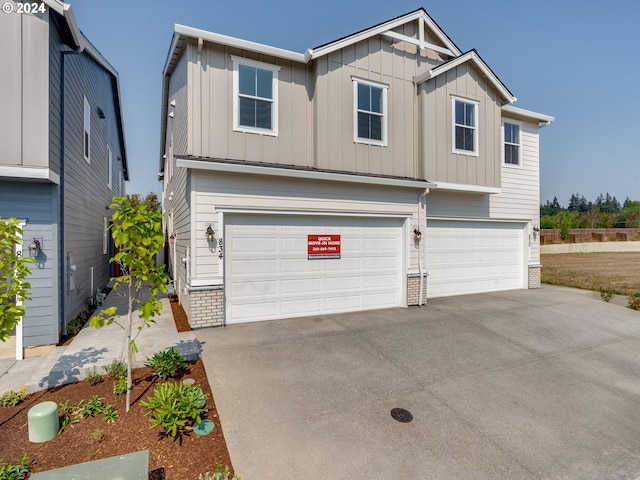 view of front of house featuring a garage, brick siding, board and batten siding, and driveway