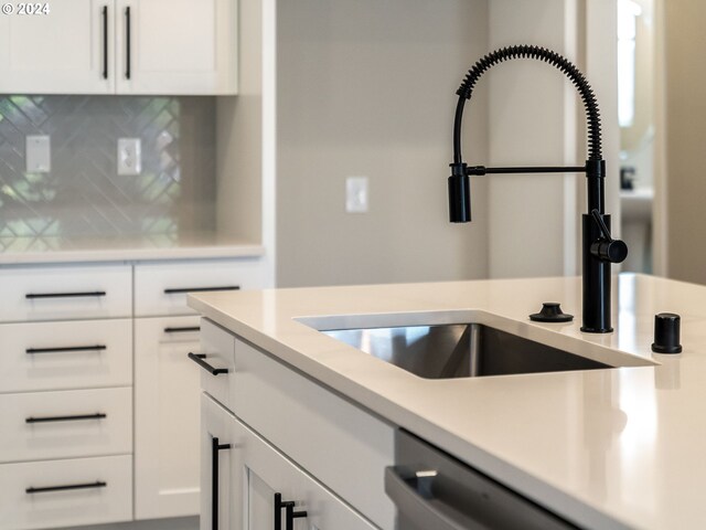 kitchen with white cabinets, dishwasher, tasteful backsplash, and sink