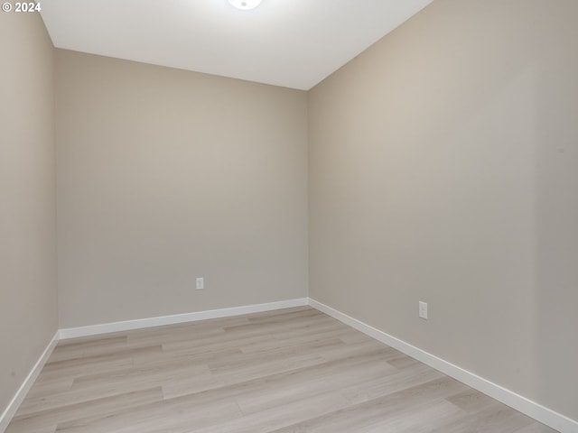 empty room with baseboards and light wood-style flooring