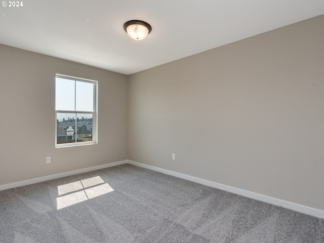 carpeted spare room with baseboards