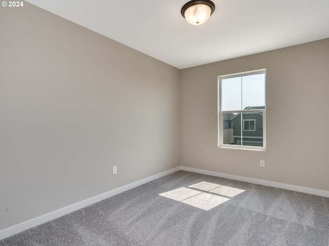 spare room featuring carpet and baseboards