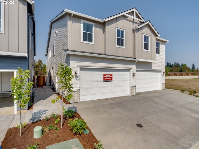 craftsman-style home with a garage, board and batten siding, and driveway