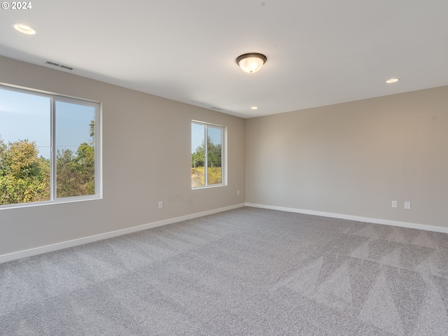 empty room featuring carpet flooring, recessed lighting, and baseboards