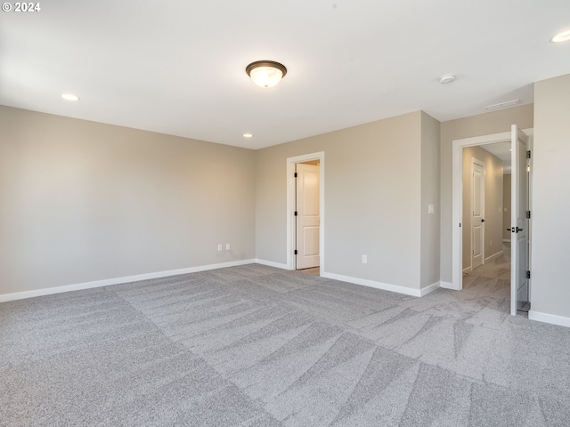 empty room featuring visible vents, recessed lighting, carpet, and baseboards