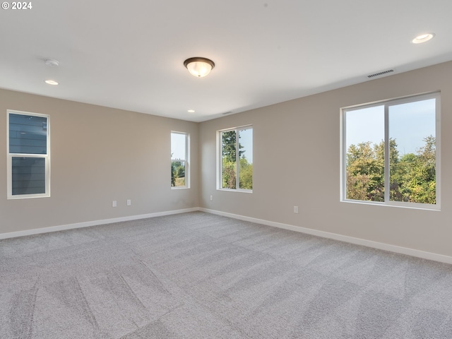 carpeted empty room with visible vents, recessed lighting, and baseboards