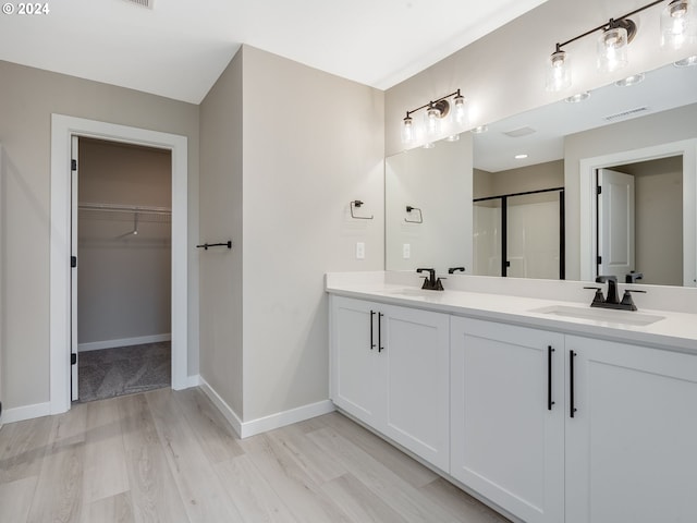 bathroom with visible vents, a shower stall, baseboards, and a sink