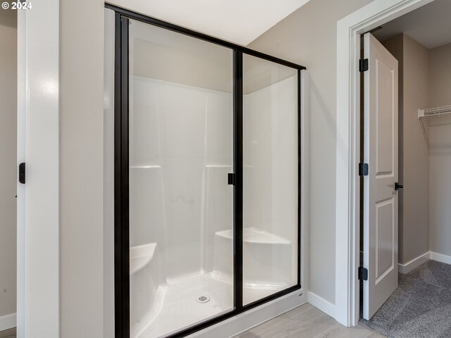 bathroom featuring walk in shower and wood-type flooring