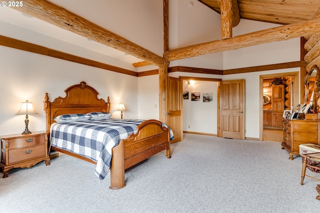 bedroom with light colored carpet, lofted ceiling with beams, and ensuite bath