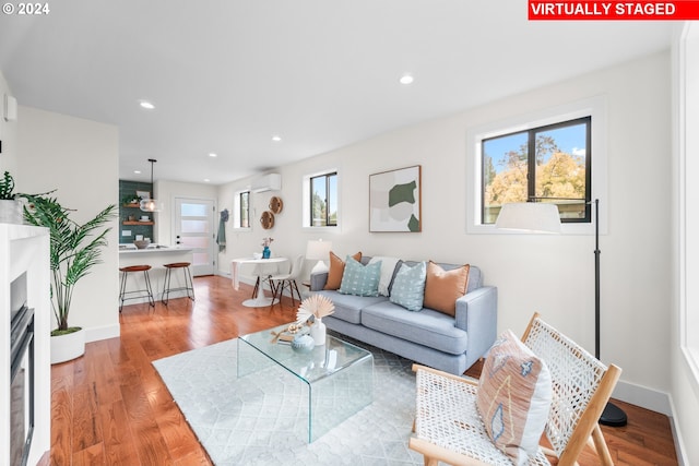 living room with hardwood / wood-style flooring and a wall unit AC