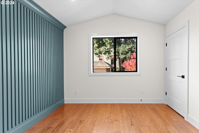 unfurnished room featuring vaulted ceiling and light wood-type flooring