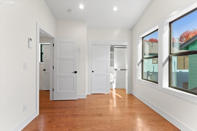 hallway featuring plenty of natural light and light hardwood / wood-style floors