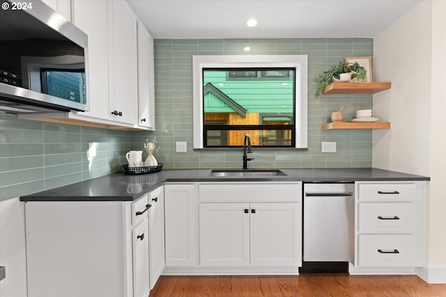 kitchen featuring white cabinetry, tasteful backsplash, sink, and light hardwood / wood-style flooring