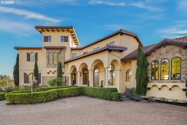 4974 W 44th Ave, Eugene, OR 97405 - mediterranean / spanish-style house featuring a tiled roof, stucco siding, and stone siding