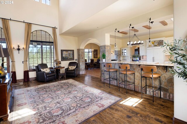 4974 W 44th Ave, Eugene, OR 97405 - living room featuring arched walkways, a towering ceiling, dark wood-type flooring, and a chandelier