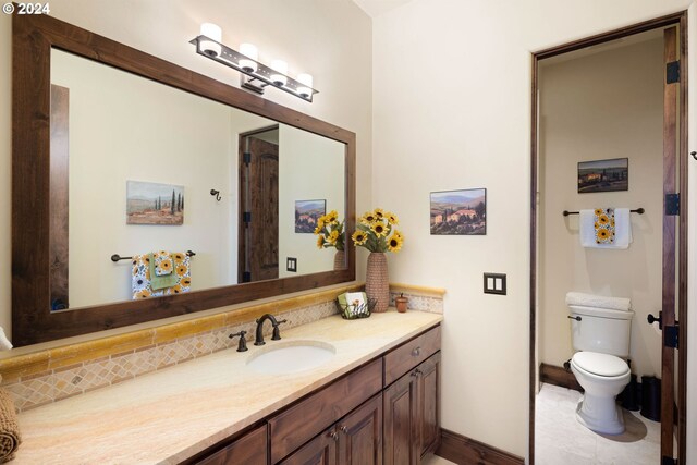 4974 W 44th Ave, Eugene, OR 97405 - bathroom featuring vanity, toilet, baseboards, and decorative backsplash