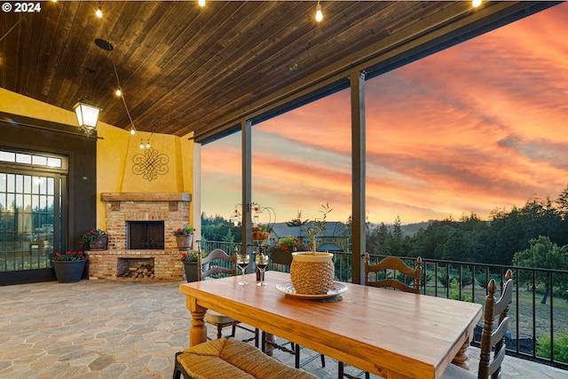 4974 W 44th Ave, Eugene, OR 97405 - dining space featuring wooden ceiling, stone finish floors, healthy amount of natural light, expansive windows, and an outdoor brick fireplace