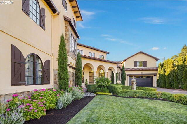 4974 W 44th Ave, Eugene, OR 97405 - mediterranean / spanish-style home featuring stone siding, an attached garage, stucco siding, and driveway