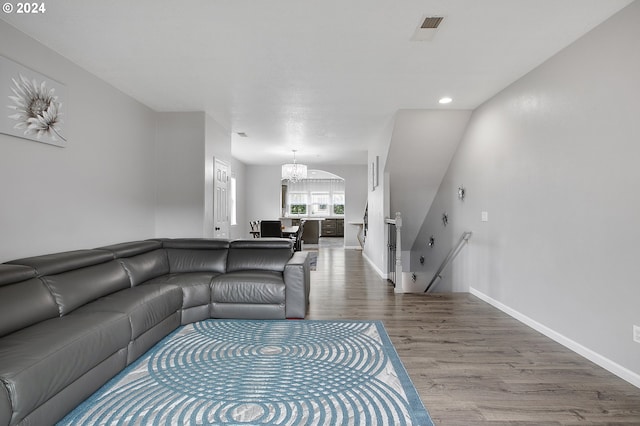 living room with wood-type flooring and an inviting chandelier