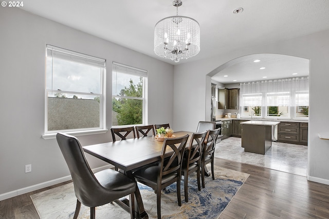 dining area featuring dark wood-type flooring and a chandelier