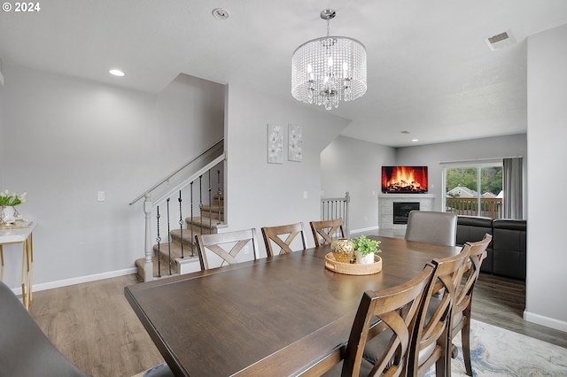 dining area featuring hardwood / wood-style flooring and an inviting chandelier