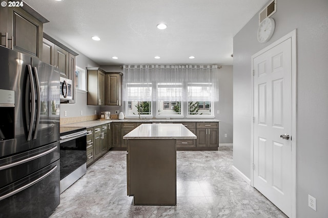 kitchen featuring a center island, dark brown cabinetry, and stainless steel appliances