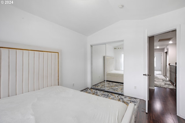 bedroom with dark hardwood / wood-style flooring, a closet, and vaulted ceiling