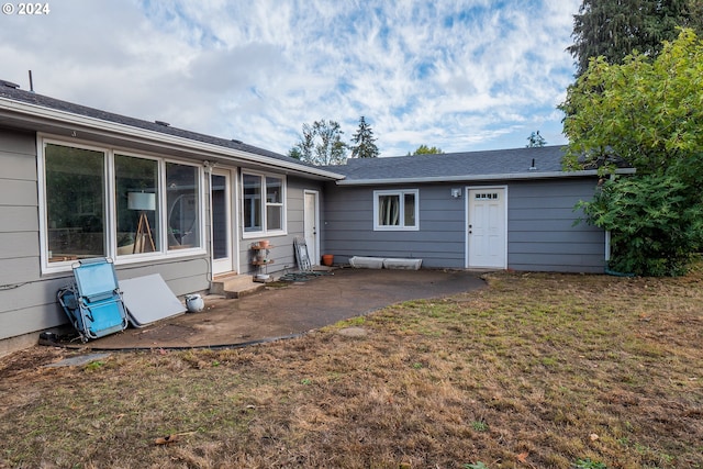 back of house with a yard and a patio