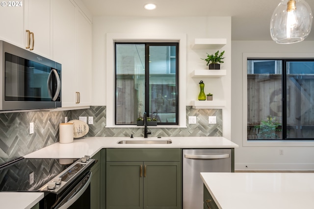 kitchen with white cabinets, sink, pendant lighting, and appliances with stainless steel finishes