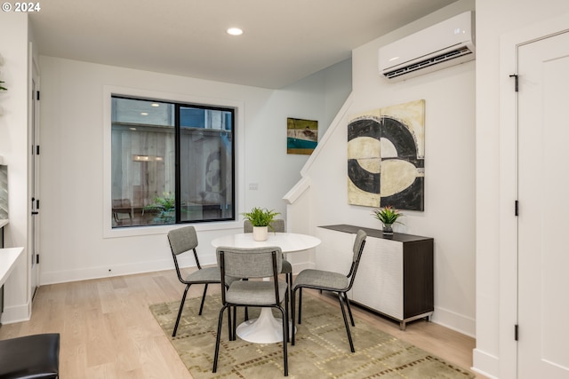 dining space featuring light wood-type flooring and a wall mounted air conditioner