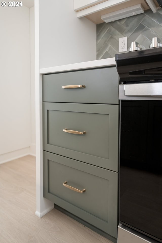 room details with decorative backsplash and light hardwood / wood-style flooring