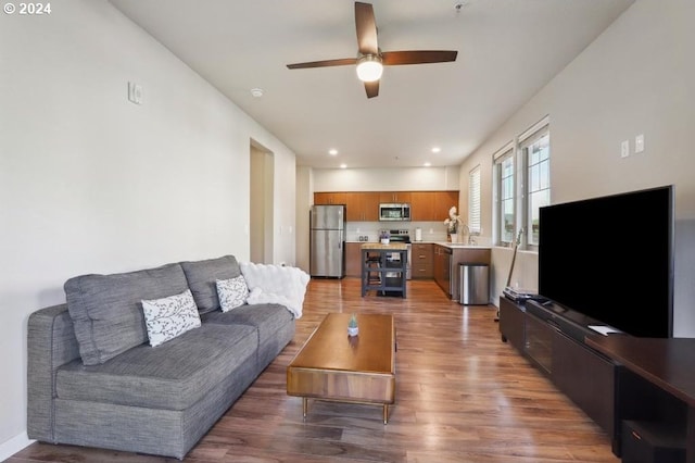 living room featuring ceiling fan, sink, and dark wood-type flooring