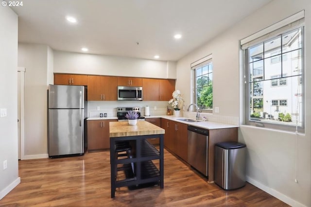 kitchen with sink, stainless steel appliances, and dark wood-type flooring