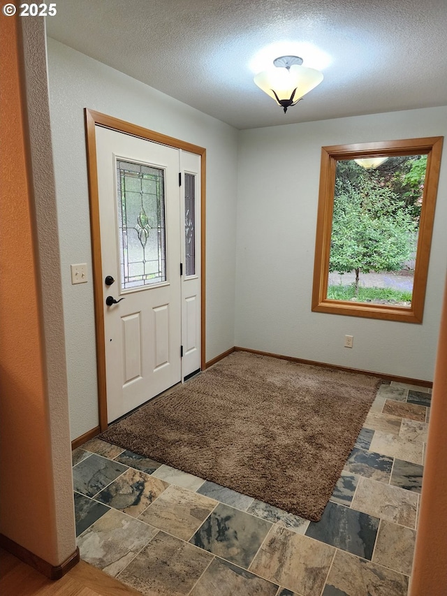 3413 Wild River Dr, Roseburg, OR 97470 - entrance foyer featuring stone tile floors, baseboards, and a textured ceiling