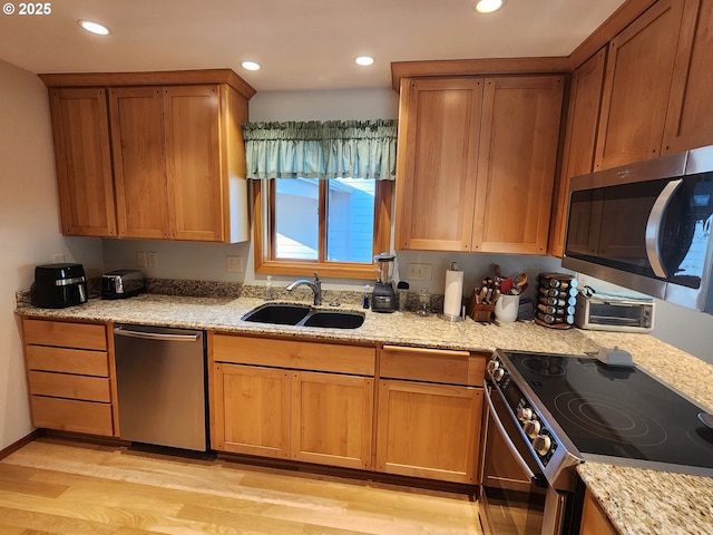 3413 Wild River Dr, Roseburg, OR 97470 - kitchen featuring appliances with stainless steel finishes, a sink, light wood finished floors, recessed lighting, and light stone countertops