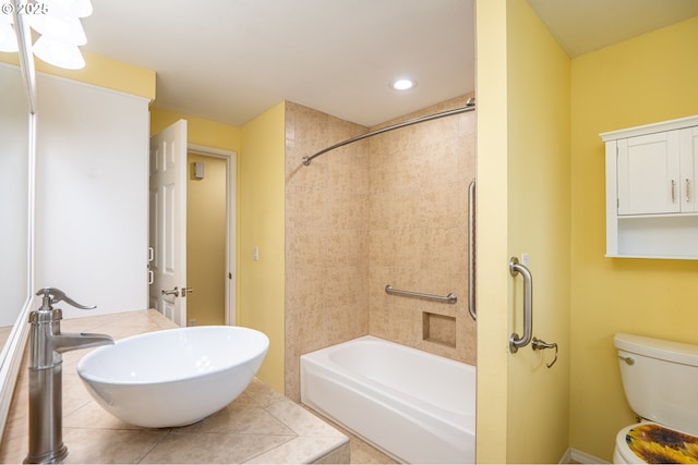 full bathroom with toilet, tiled shower / bath combo, and sink