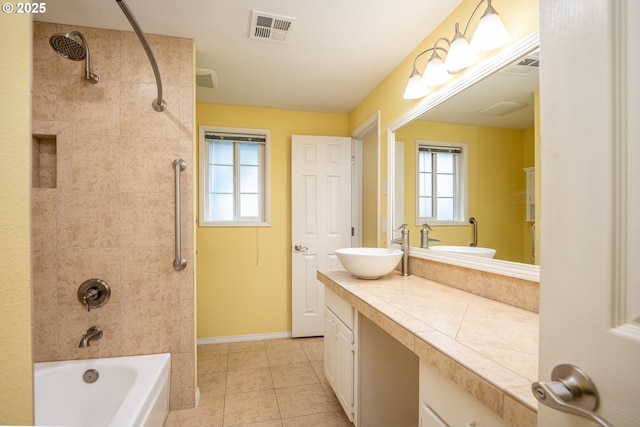 bathroom with tiled shower / bath, vanity, and tile patterned floors