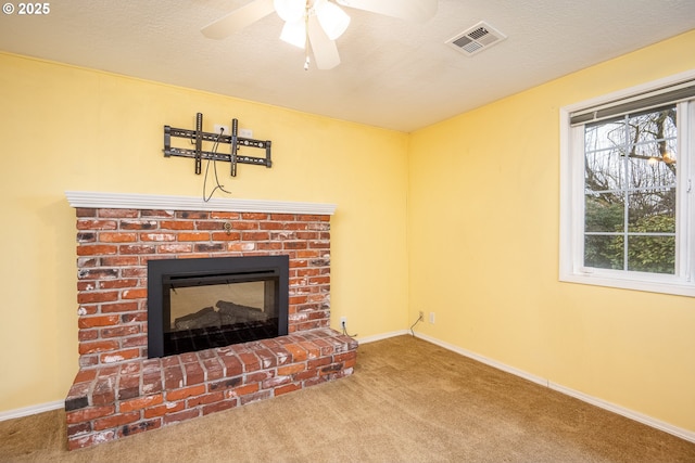 living room with a brick fireplace, carpet floors, a textured ceiling, and ceiling fan