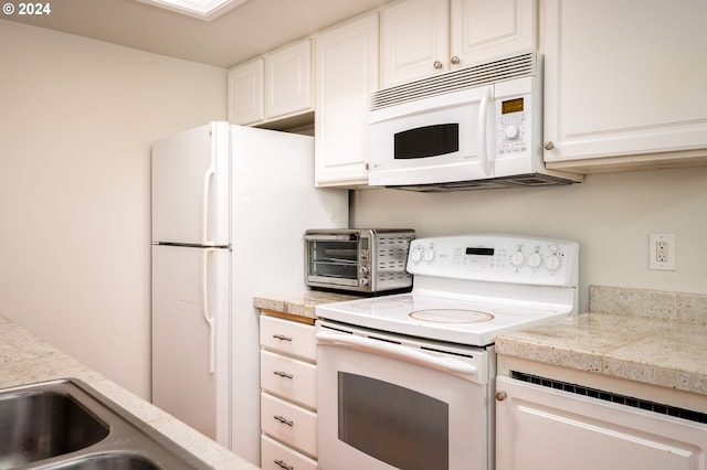 kitchen featuring white cabinets and white appliances