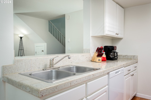 kitchen with dishwasher, kitchen peninsula, white cabinetry, and sink