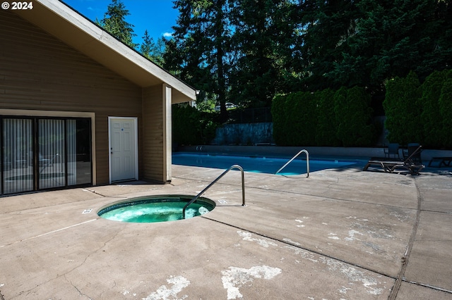 view of swimming pool with a patio and a community hot tub