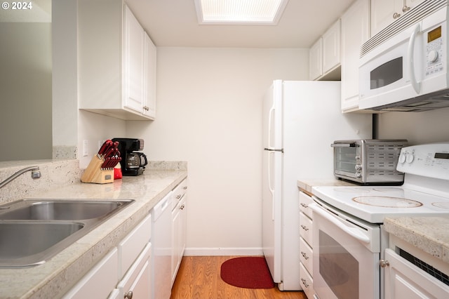 kitchen with light wood-type flooring, white appliances, white cabinetry, and sink