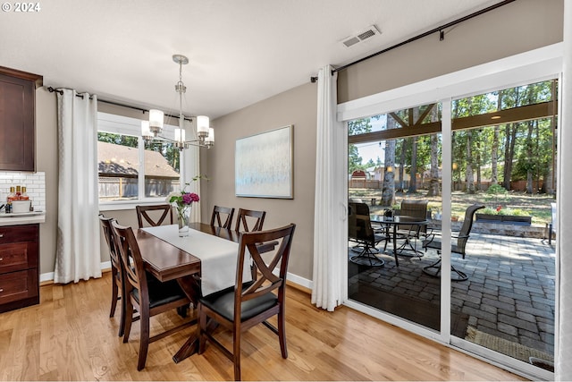 dining space featuring light hardwood / wood-style floors and an inviting chandelier