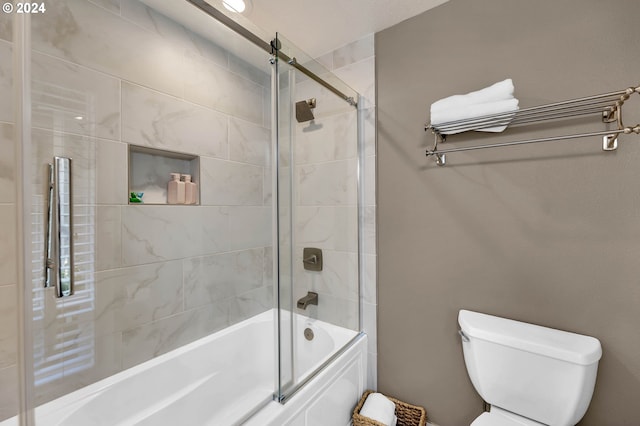 bathroom featuring shower / bath combination with glass door and toilet