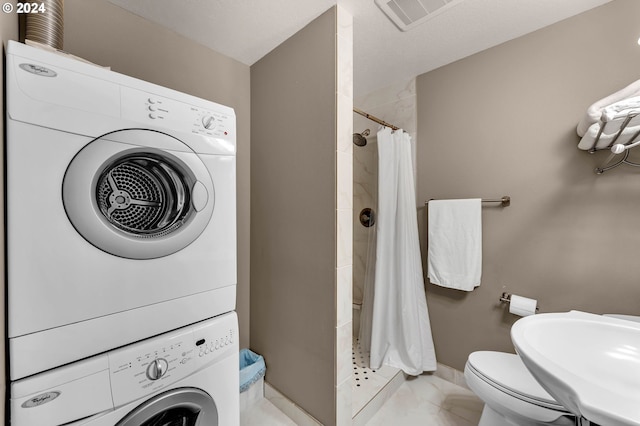 laundry area featuring sink and stacked washer and dryer