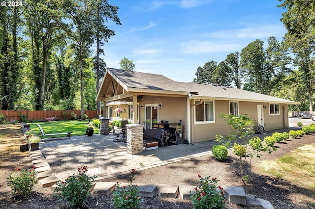 rear view of property featuring a lawn and a patio