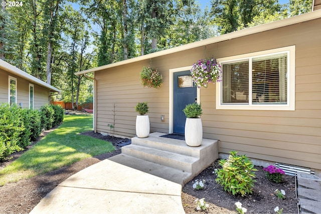 view of exterior entry featuring a yard